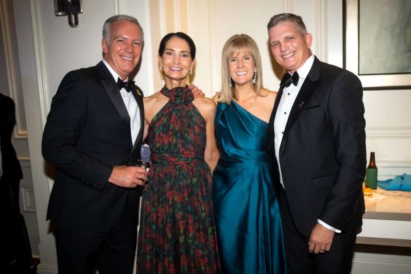 Elegant group of four at Believe Ball charity event in formal attire.