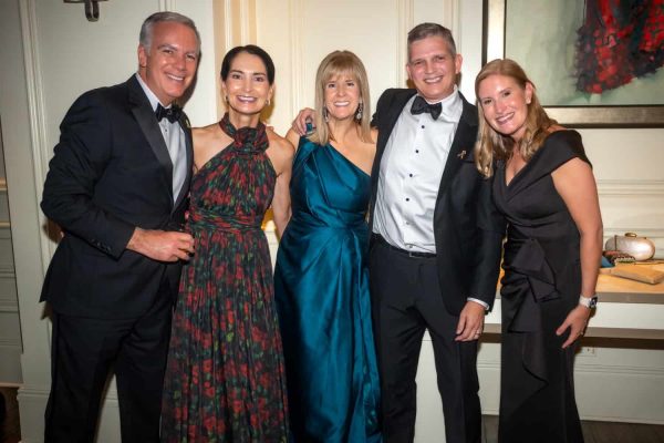 Group of five elegantly dressed people at Believe Ball event.