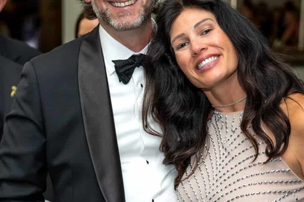 Smiling couple at Believe Ball event in formal attire.