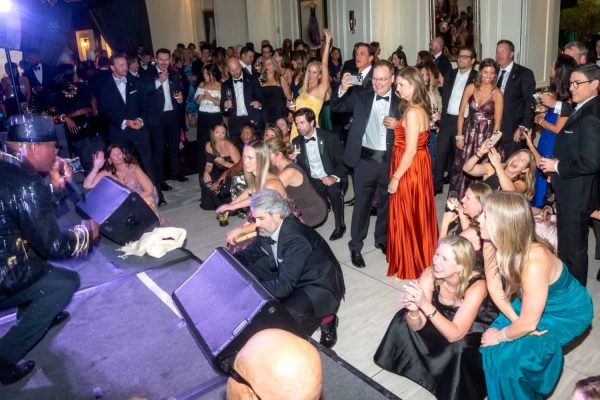 People dancing and enjoying live music at Believe Ball event in an elegant venue.