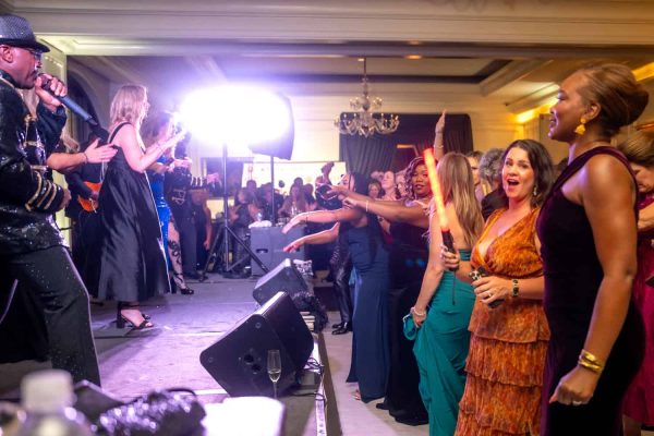 People dancing and enjoying live music at Believe Ball event.
