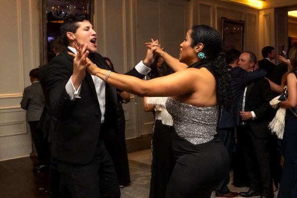 People dancing at Believe Ball charity event in formal attire.