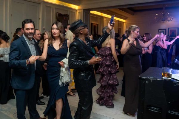 People dancing and enjoying at the Believe Ball event in a luxurious venue.