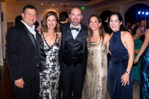 Group of five people dressed in formal attire at Believe Ball event.