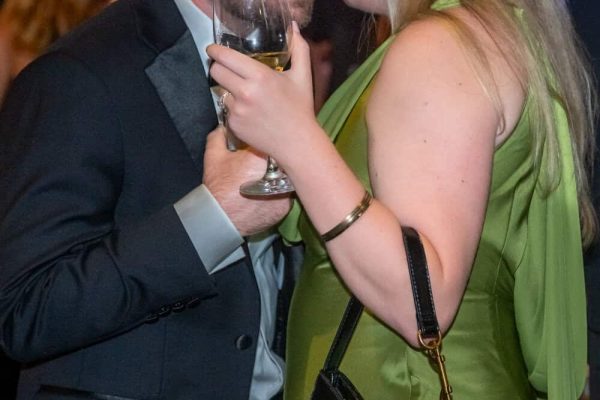Elegant couple at Believe Ball sharing a drink and intimate moment.