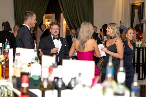 Guests socializing at the Believe Ball charity event in an elegant venue.