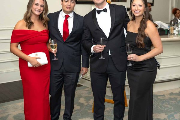 Group of four elegantly dressed people at Believe Ball event.