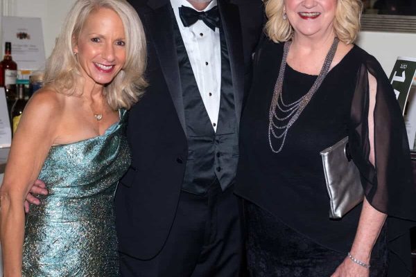 Three elegantly dressed people at the Believe Ball event in 2026.