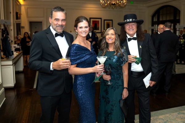 Group of four people in formal attire at Believe Ball event.