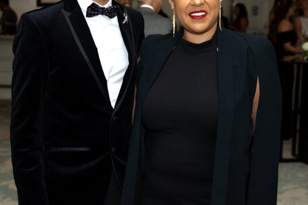 Elegant man and woman at Believe Ball event in formal attire.