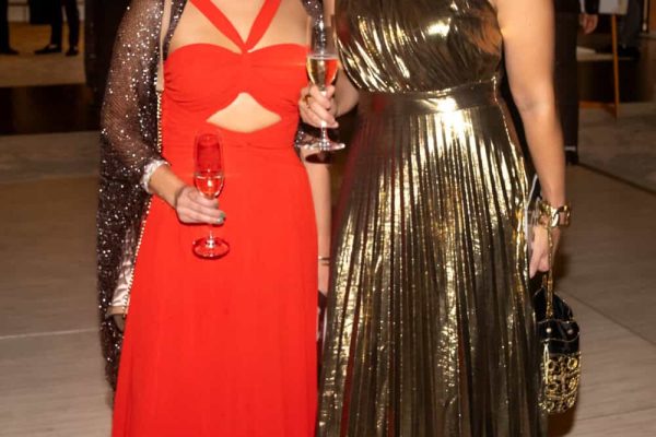 Two women in elegant evening gowns at Believe Ball event in 2026.