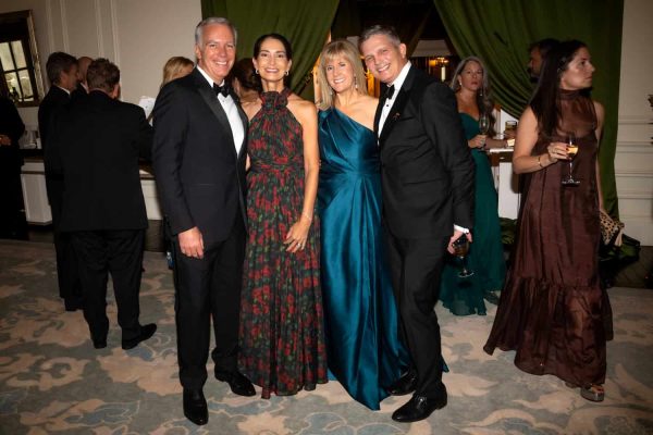 Elegant group of four people at Believe Ball event in formal attire.